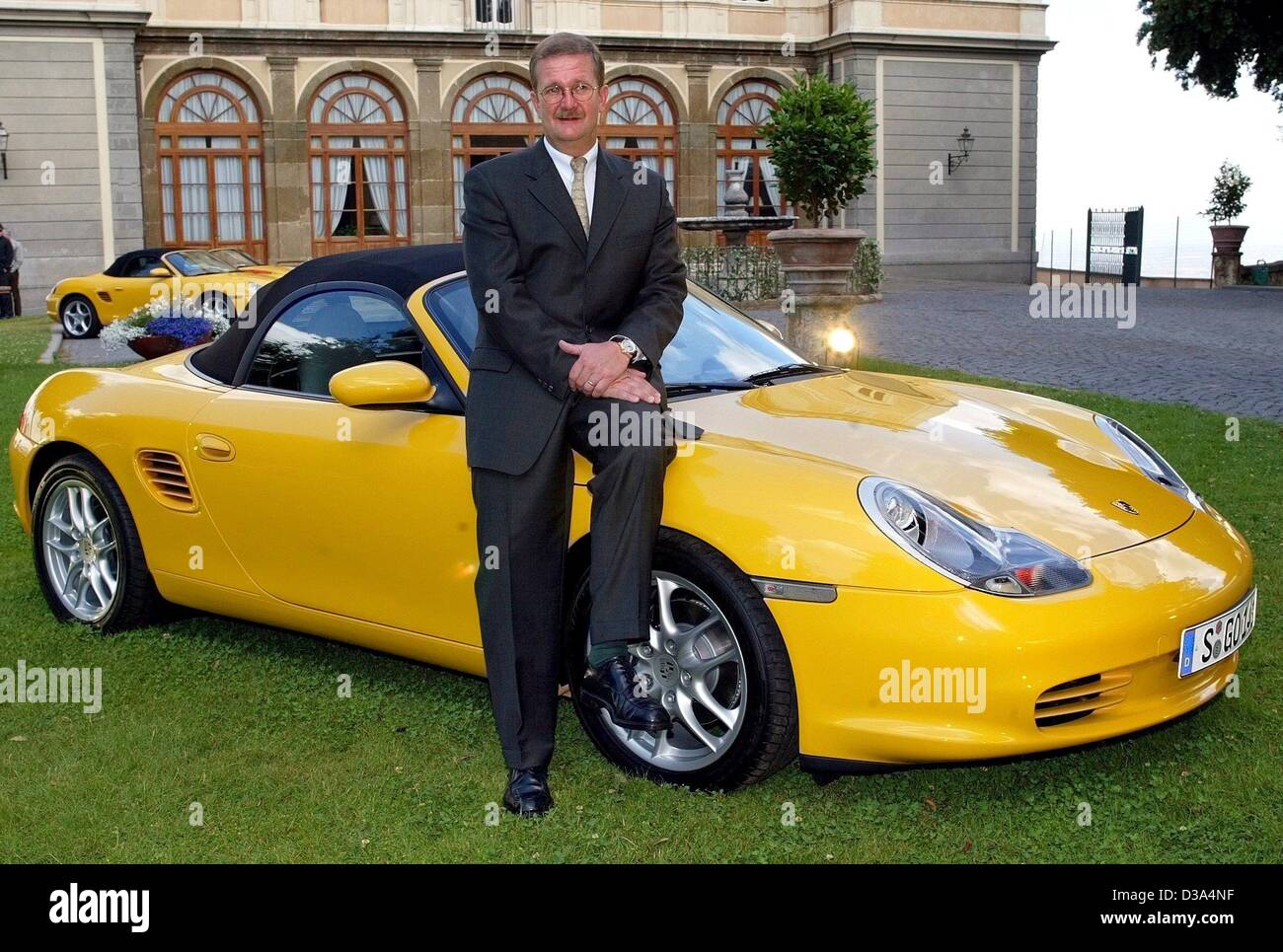(dpa) - Wendelin Wiedeking, CEO of the German sports car manufacturer Porsche, poses with the new Boxster in Rome, 10 June 2002. The reengineered Boxster will be sold at unchanged prices as of August, offering improved performance, furnishing and equipment. Wiedeking said the Boxster was of great st Stock Photo