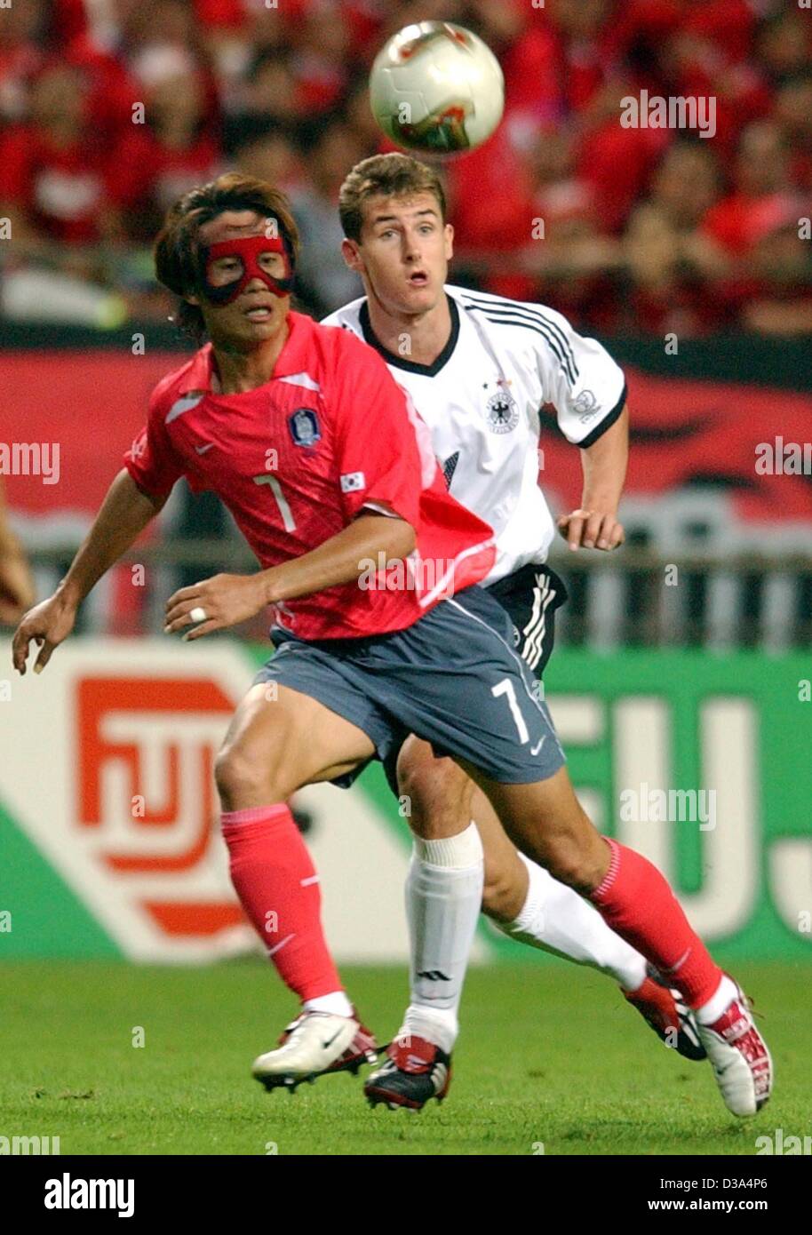 (dpa) - German striker Miroslav Klose (R) and Korean defender Kim Tae-Young both run after the ball in the semi final of the FIFA World Cup in Seoul, 25 June 2002. By beating South Korea 1:0 Germany qualified for the 7th time for the World Cup final. Stock Photo