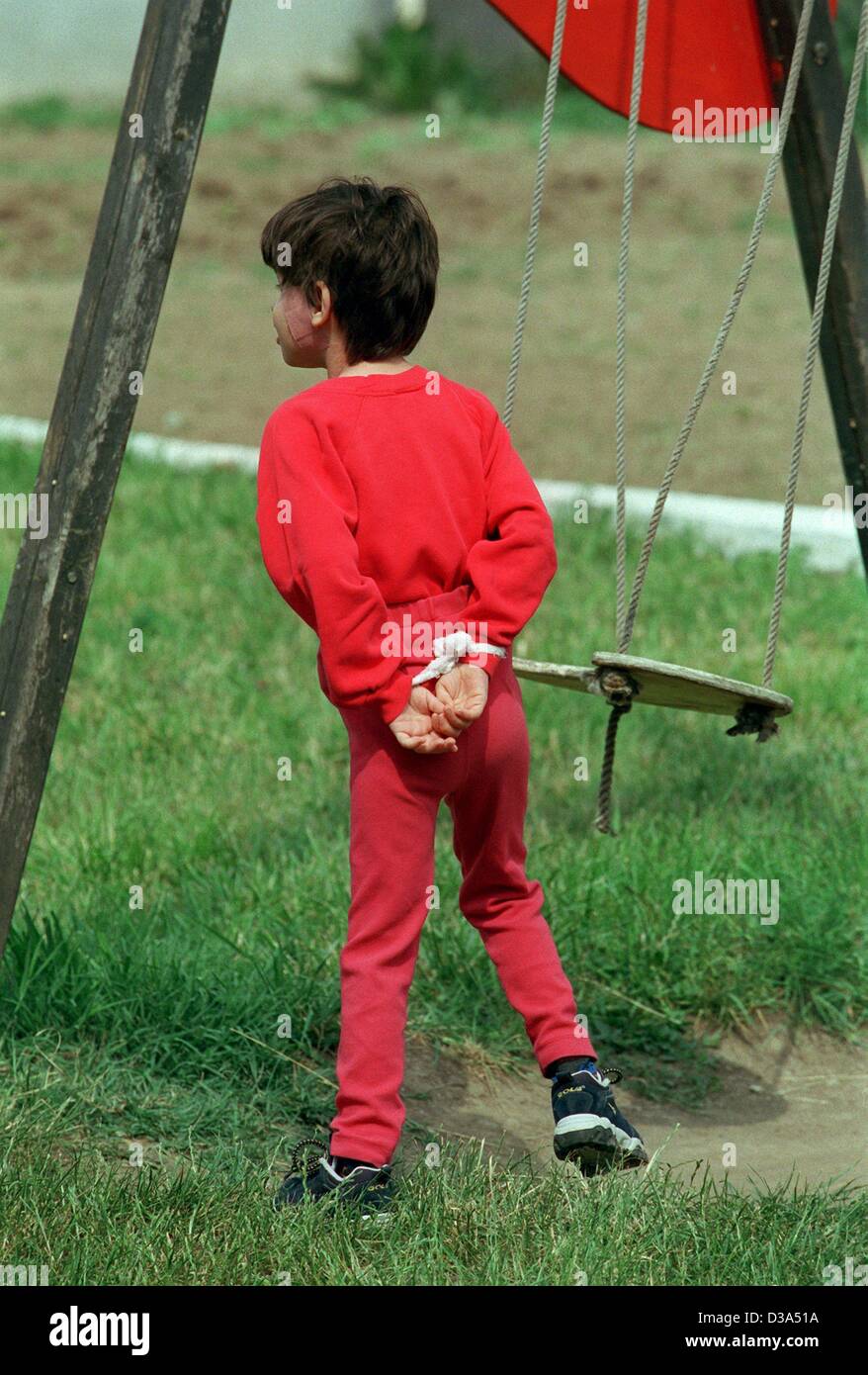 dpa files) - A girl suffering from self-mutilation is walking over the  playground with tied up hands, at the hospital 'Casa Speranta' in Romania,  2 June 2001. The 'House of Hope' is