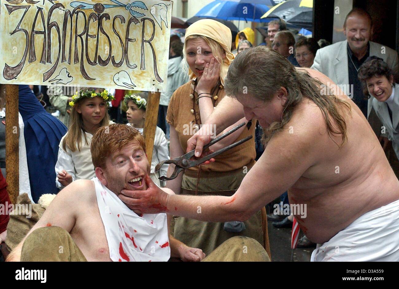 (dpa) - The work of a medieval 'tooth ripper' is re-enacted by members of the 'Historia Viva' club during the 'Luther's Wedding' pageant in Wittenberg, east Germany, 8 June 2002. The day marked the 477th wedding anniversary of reformer Martin Luther and the nun Katharina von Bora. Stock Photo