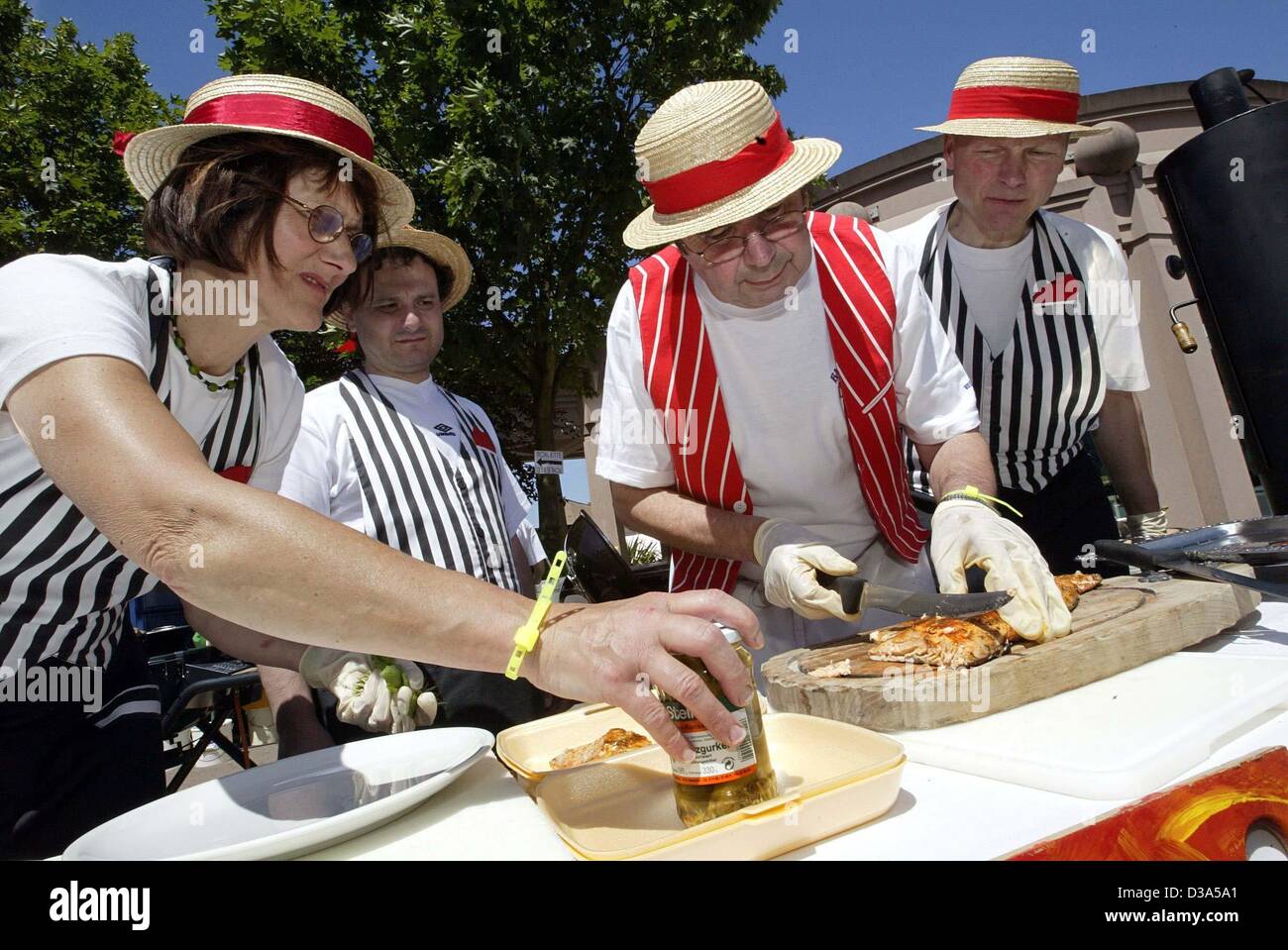(dpa) - The team 'The 5 Swabians' from Tuebingen prepare salmon as a main course at the German Barbecue Championships in Pirmasens, Germany, 2 June 2002. Lore Wizemann (L-R), Tommaso Cremona, Siegfried Kammueller and Horst Wizemann were able zo defend their title in this year's championships. Stock Photo