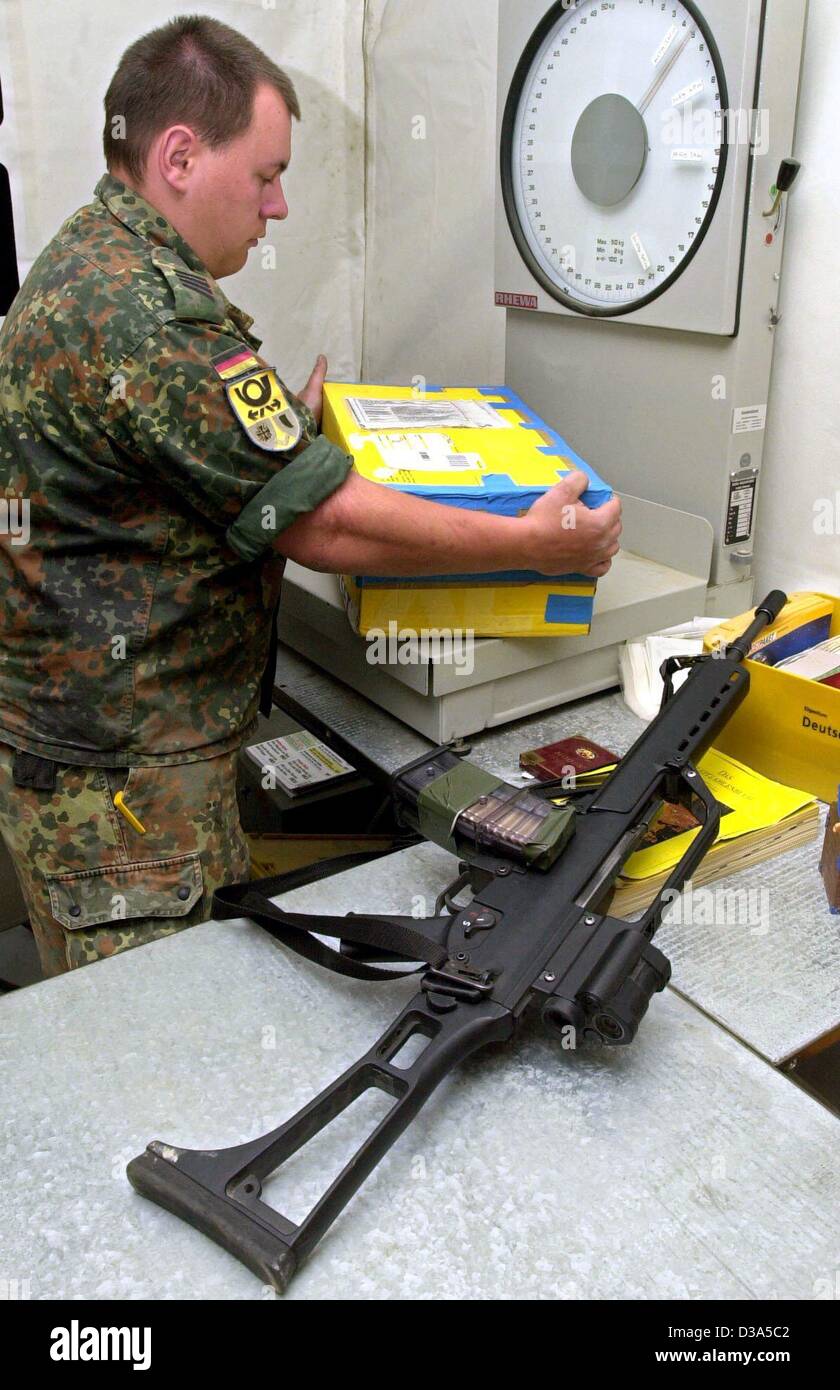 (dpa) - A German soldier of the International Security Assistance Force (ISAF) weighs a parcel in the post office in the military camp near Kabul, Afghanistan,  29 March 2002. Mail-wise the ISAF camp is regarded as German ground, so that letters and pacels can be sent off with German stamps. Roughly Stock Photo