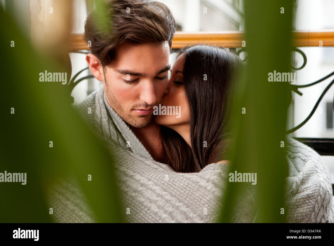 Kissing couple wrapped in blanket Stock Photo