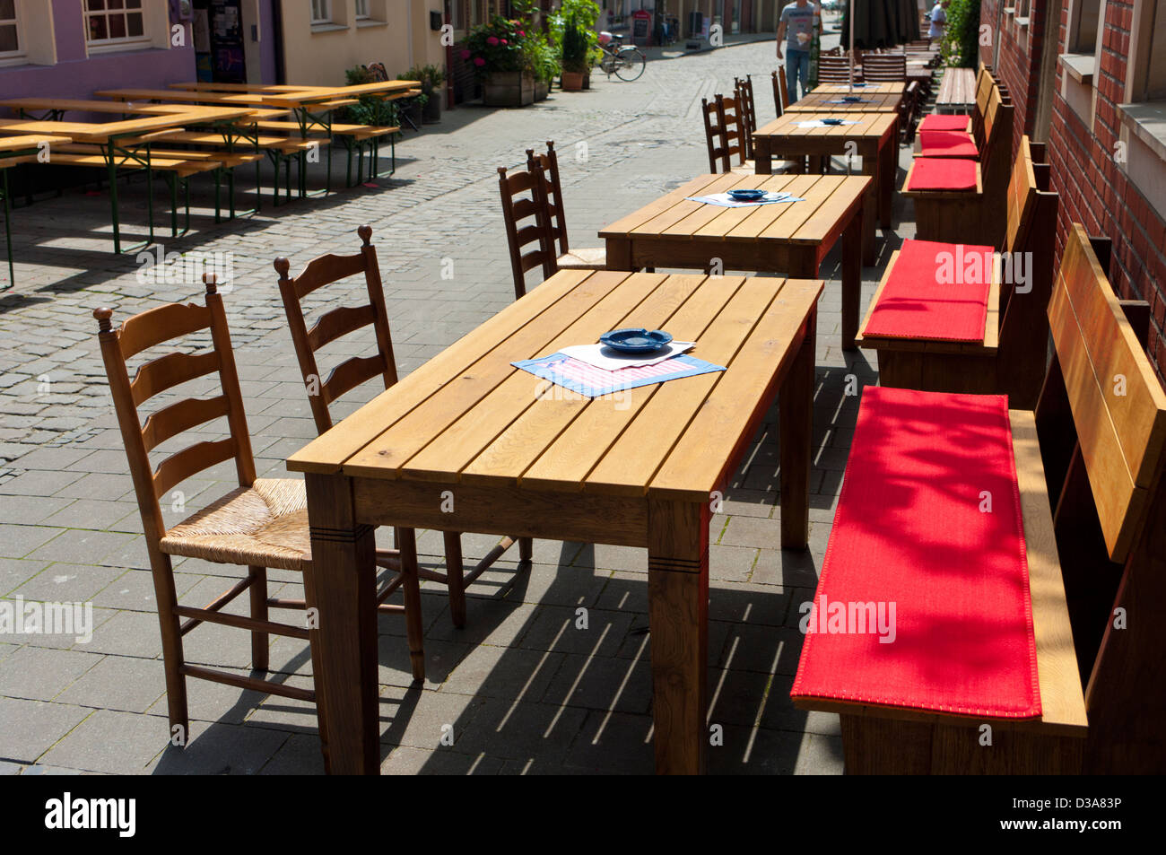 typical german street terrace with large wooden tables and chairs in