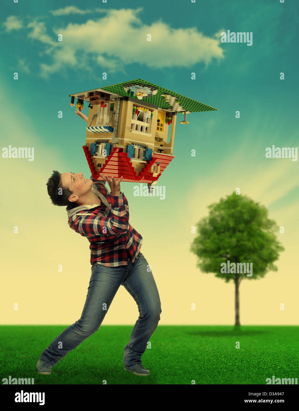 woman holding up with difficulty a small model house Stock Photo