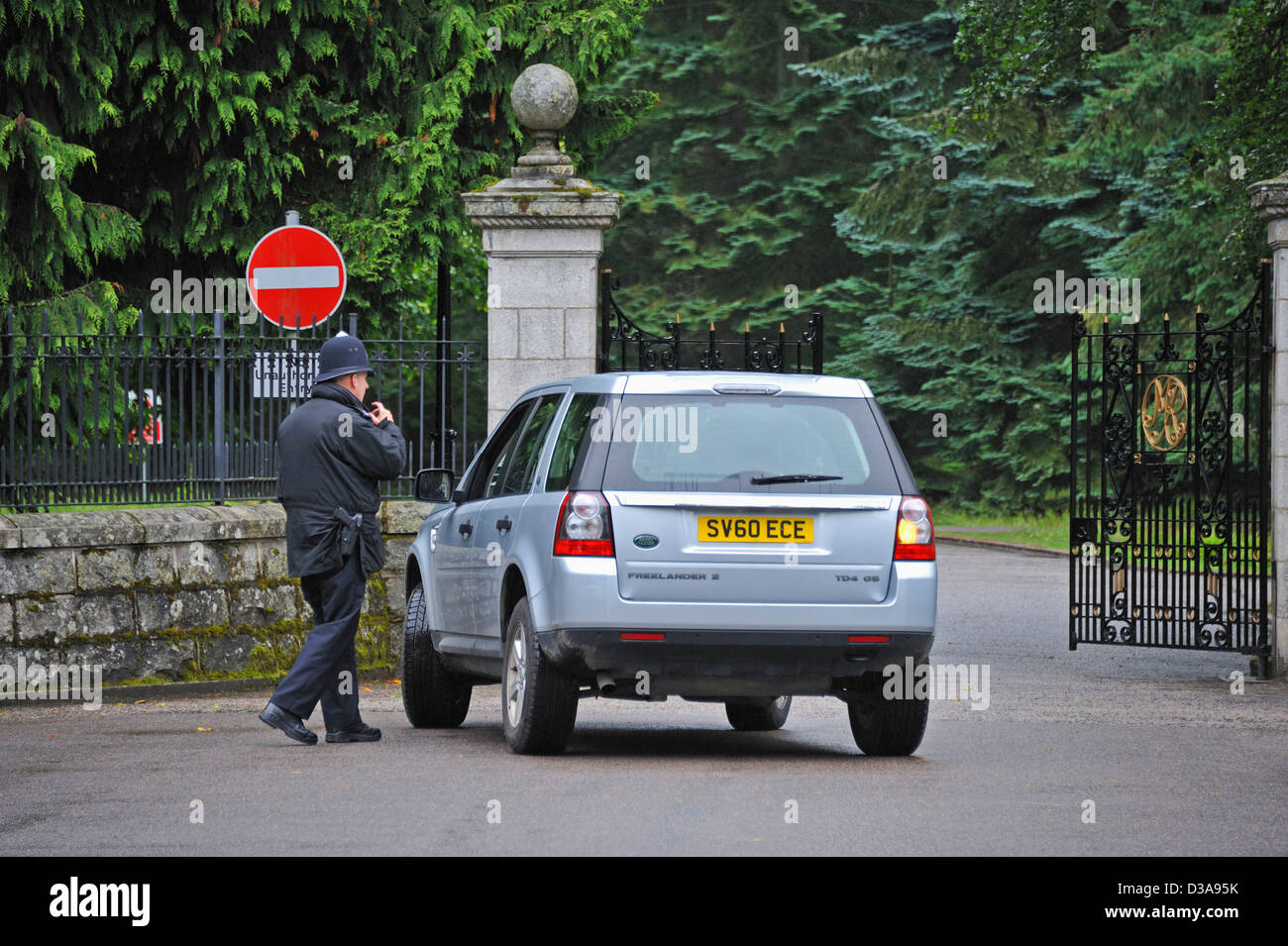 Armed police officer at main entrance gates to the Balmoral Estate. Royal Deeside, Aberdeenshire, Scotland, United Kingdom. Stock Photo