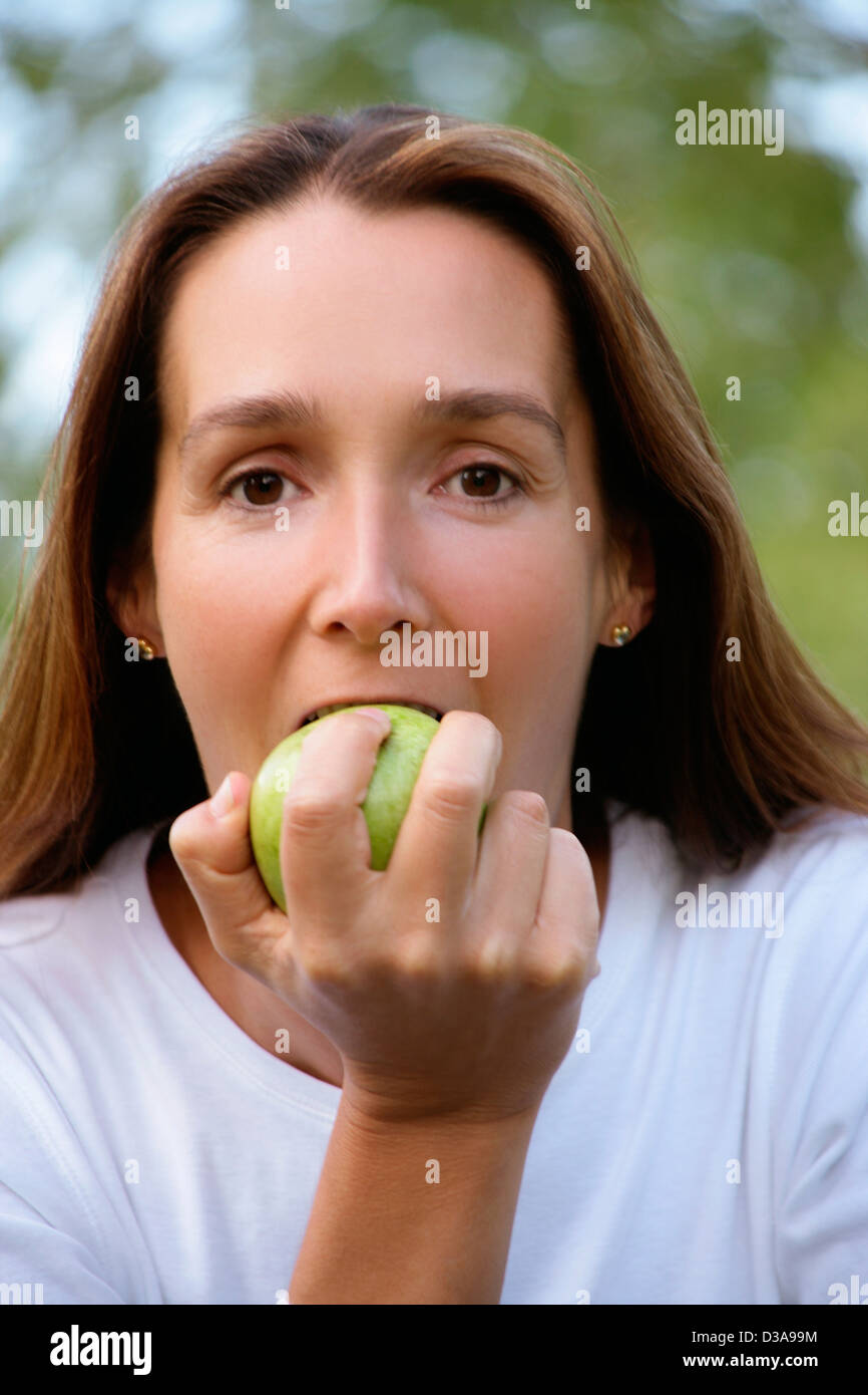 Woman eating apple outdoors Stock Photo Alamy