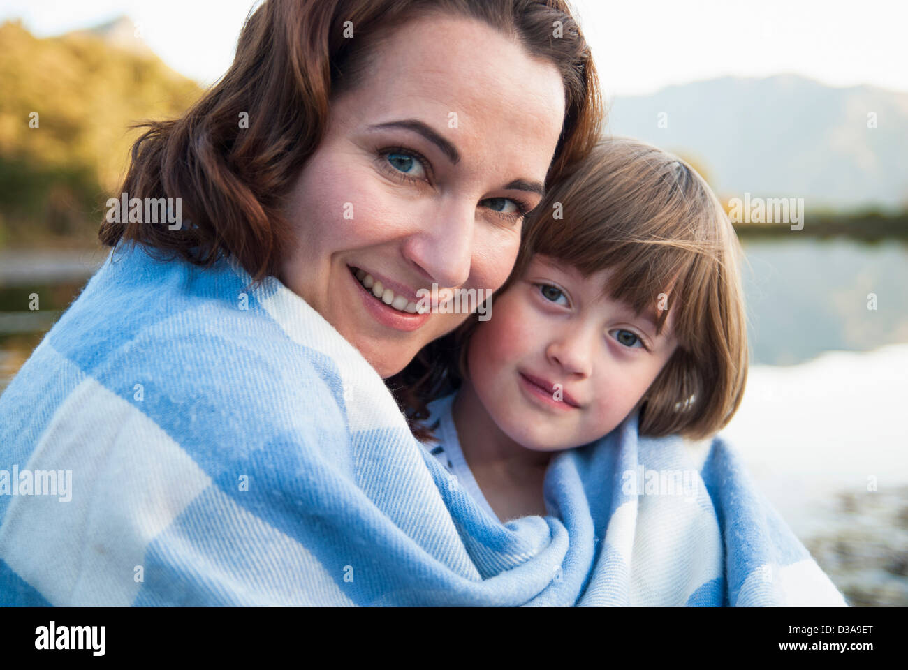 Mother and daughter wrapped in blanket Stock Photo Alamy