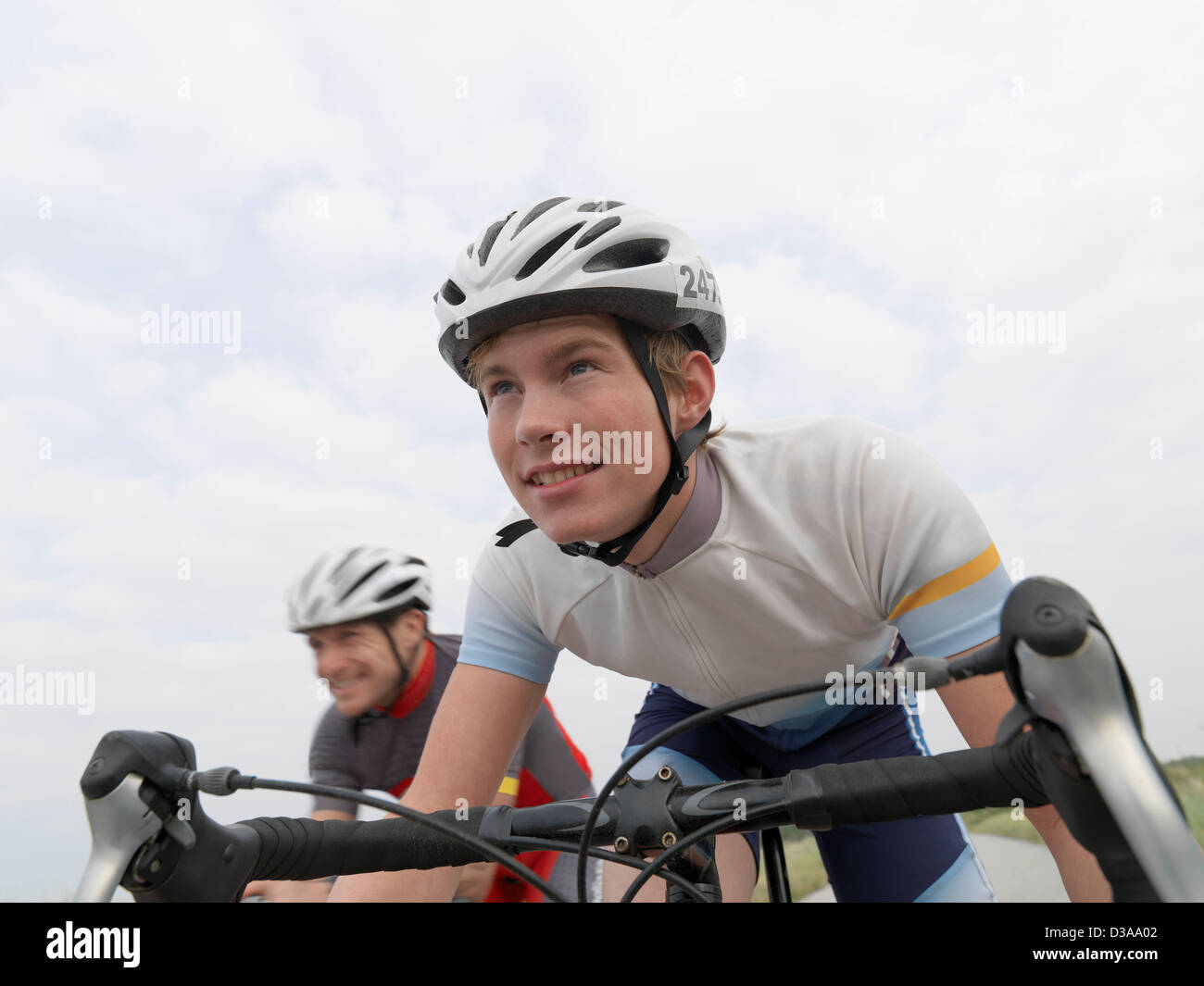 Father and son cycling on rural road Stock Photo