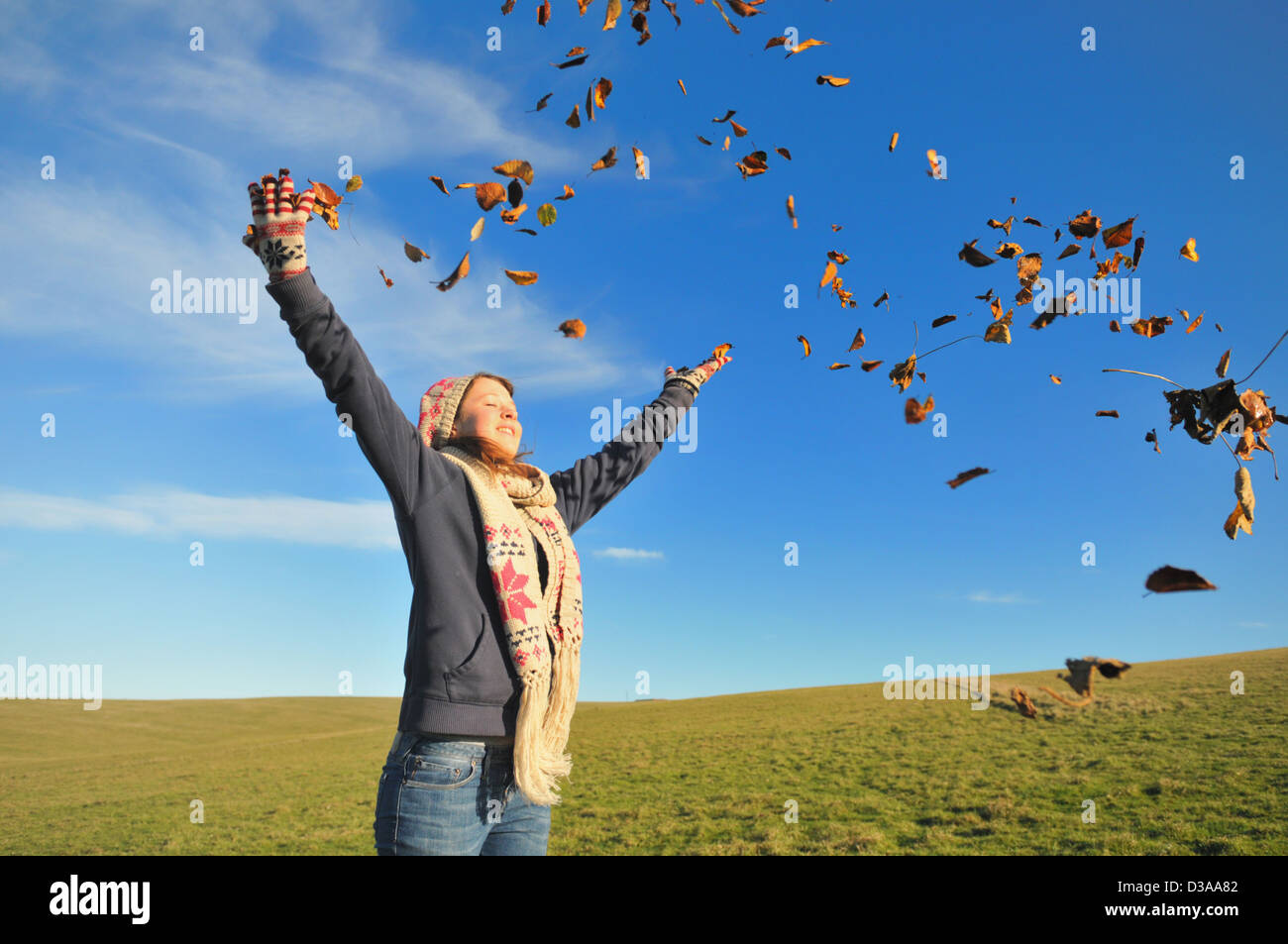 Woman playing in autumn leaves Stock Photo
