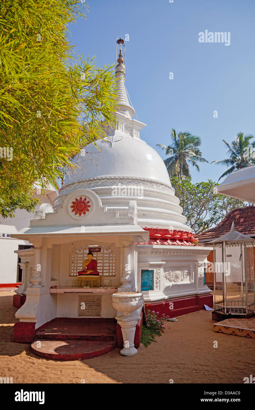 A small stupa containing a Buddha rupa in the coastal fishing village of Mirissa in southern Sri Lanka. Stock Photo
