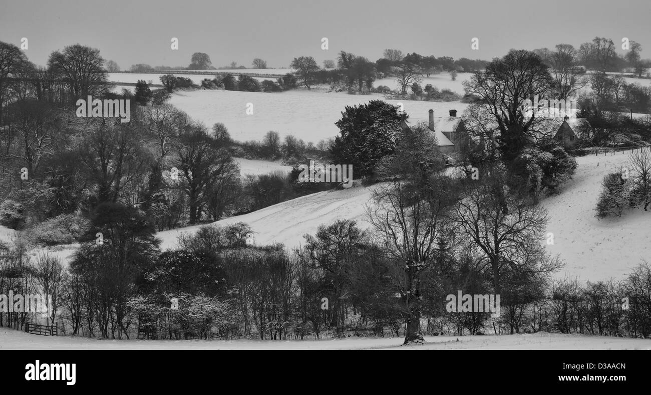 Farmhouse in a Snowy Cotswolds Valley Stock Photo