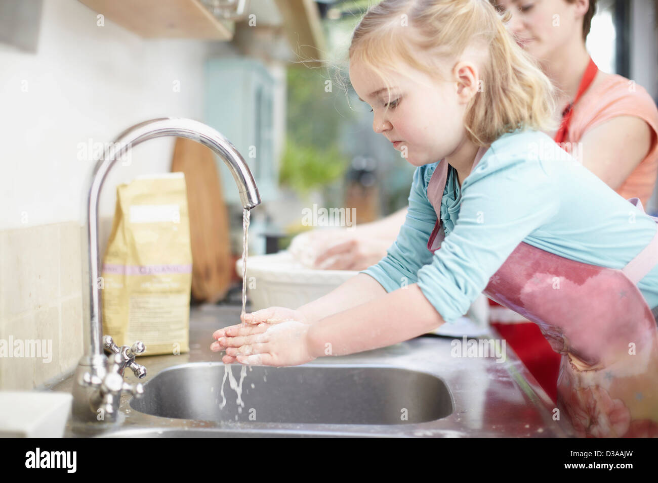 Girl washing her hands in kitchen Stock Photo Alamy