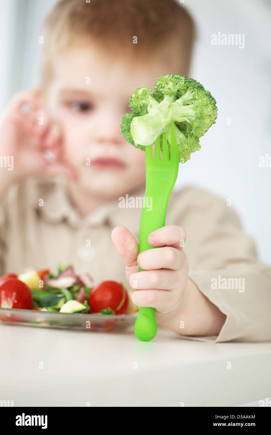 Boy examining forkful of broccoli Stock Photo