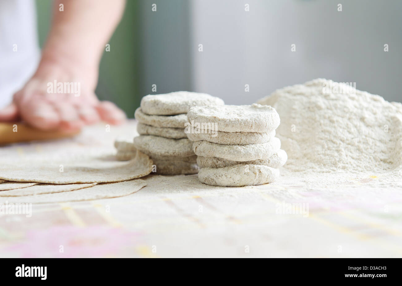 Woman with a rolling pin rolls skantsy for Karelian pies Stock Photo