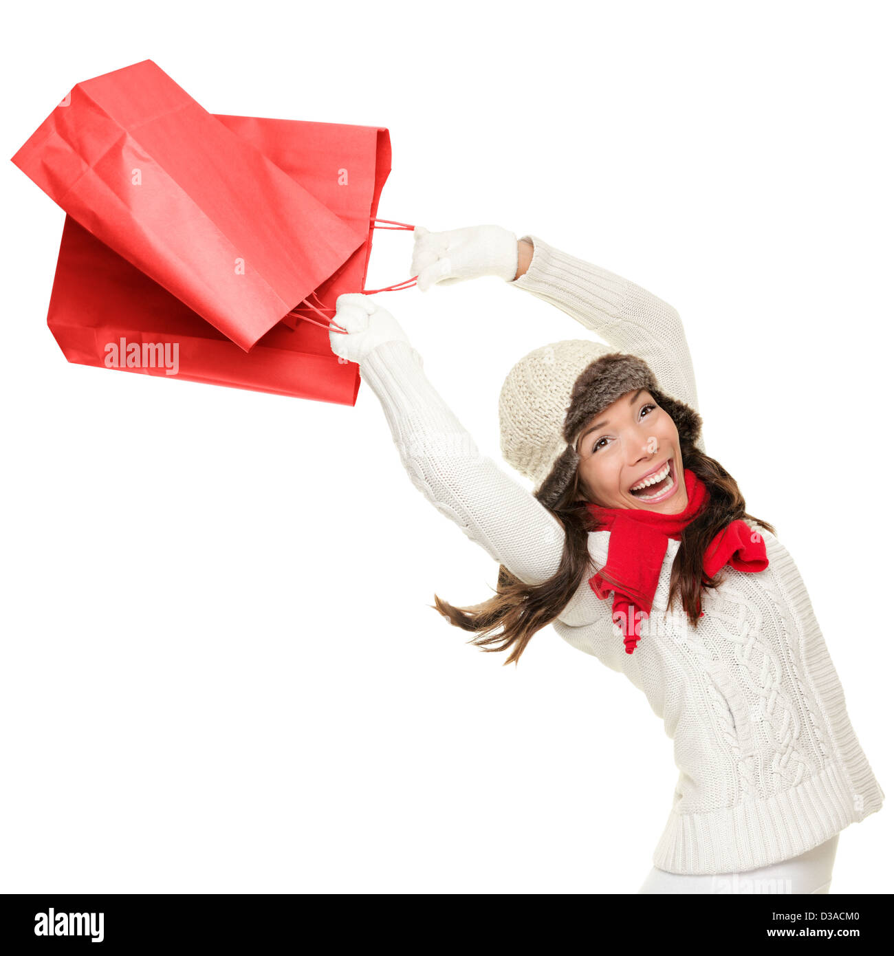 Winter and Christmas shopping. Cheerful young woman holding red shopping bags isolated on white background Stock Photo