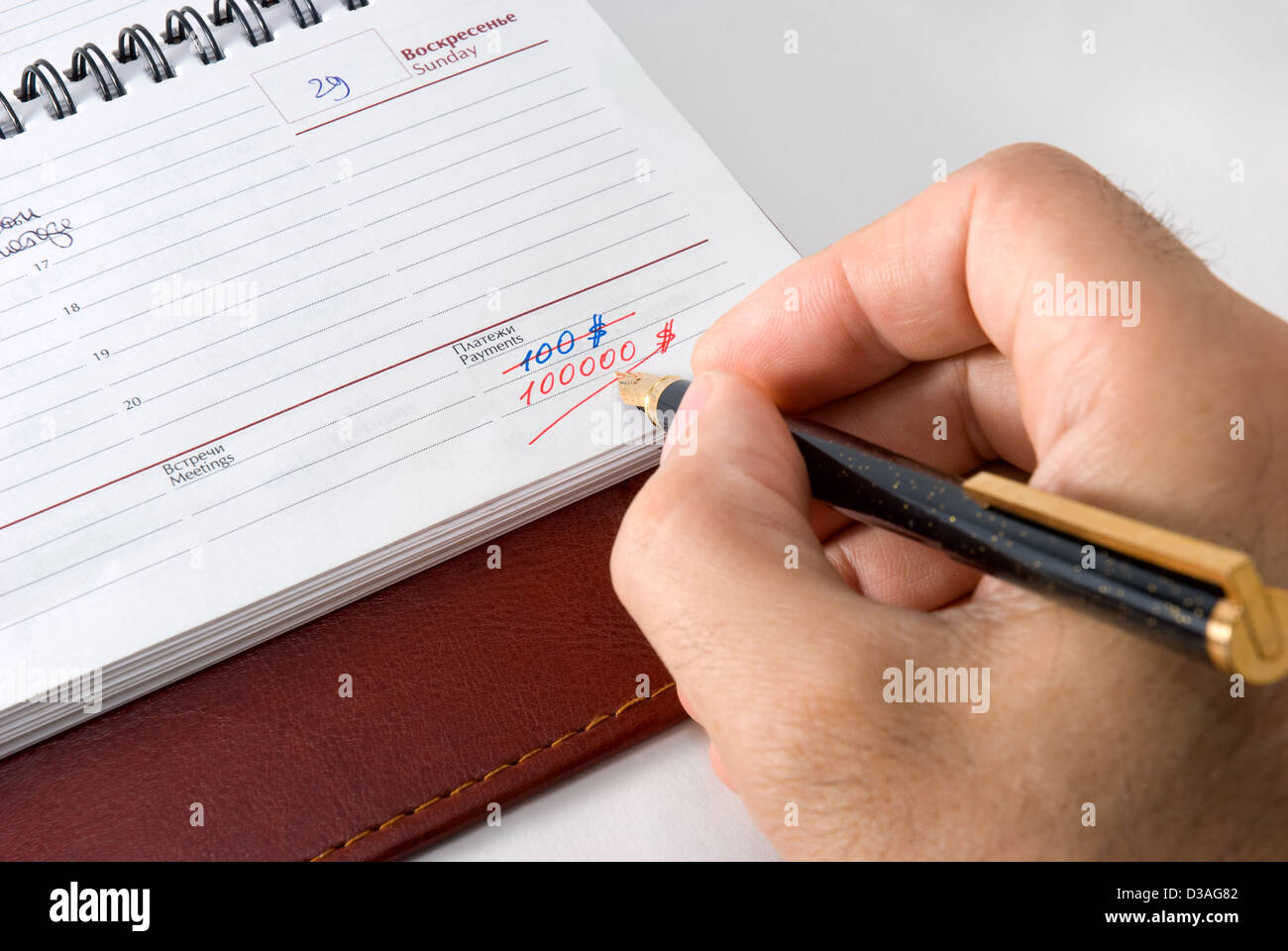 The man writing down in weekly Stock Photo