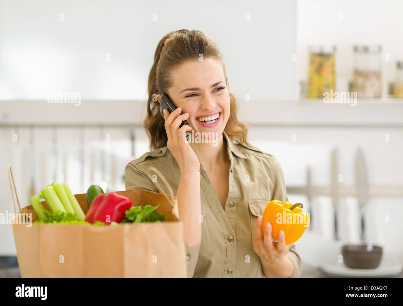 Young housewife sort purchases after shopping and talking mobile phone Stock Photo