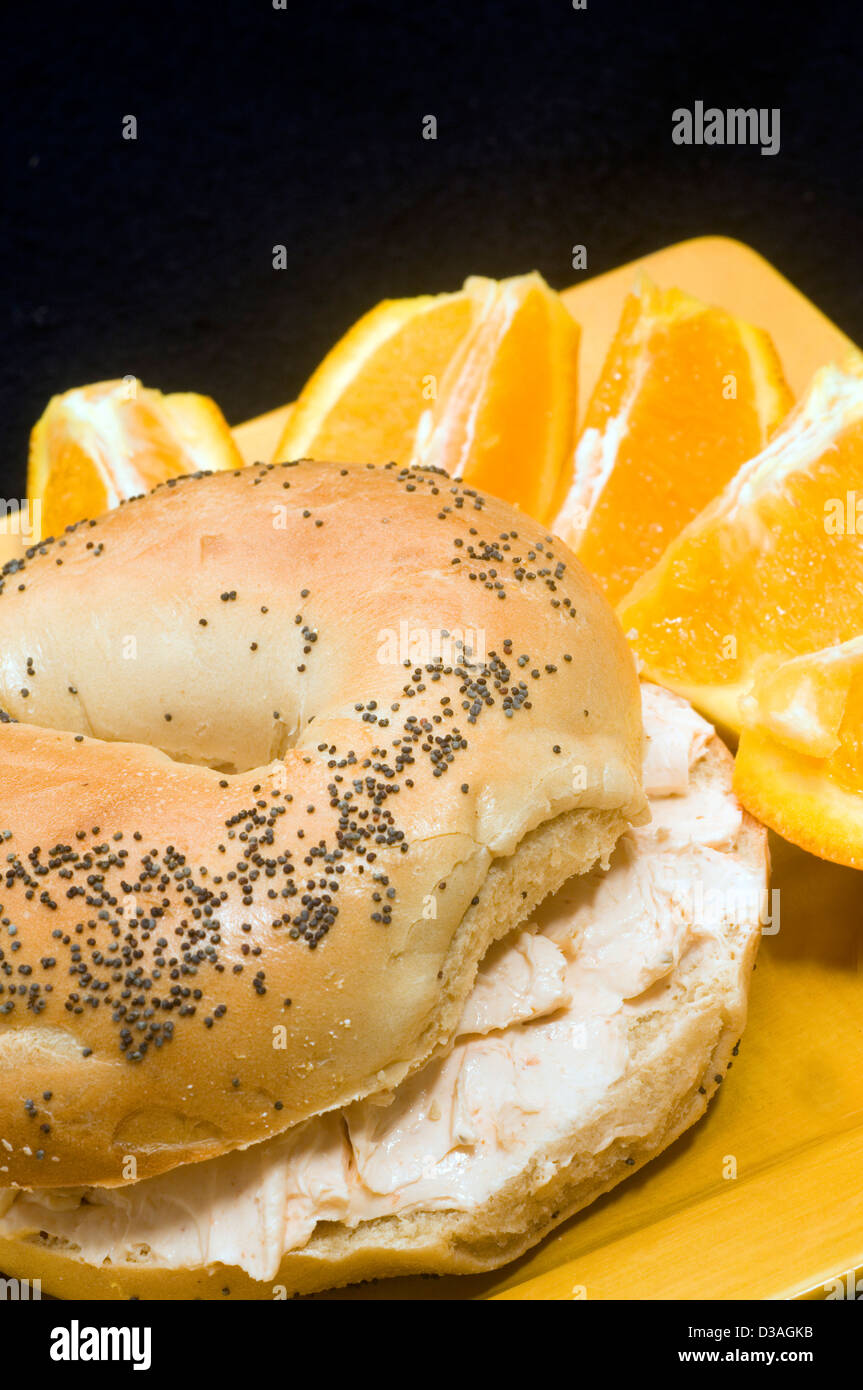 poppy seed bagel with smoked salmon cream cheese spread and fresh navel orange Stock Photo