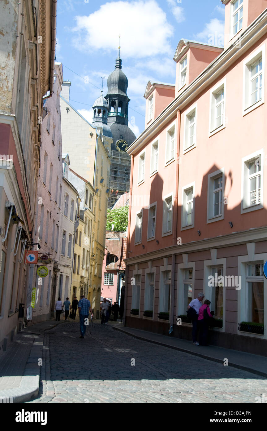 One of the many cobbled stone streets, Kramu iela and the Church of St.Peter's spire in Riga old town, Riga, Latvia, Baltic States Stock Photo