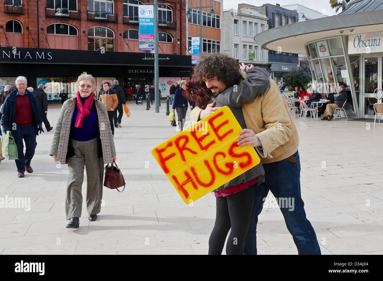 Bournemouth, UK. 14th February 2013. The free Hugs campaign involves individuals who offer hugs to strangers. The intention is to make others feel better as a result of a random act of kindness. Chris, the young man in the picture, said 'hugs should be for every day and not just Valentines Day'. Credit: Tom Corban/Alamy live News Stock Photo