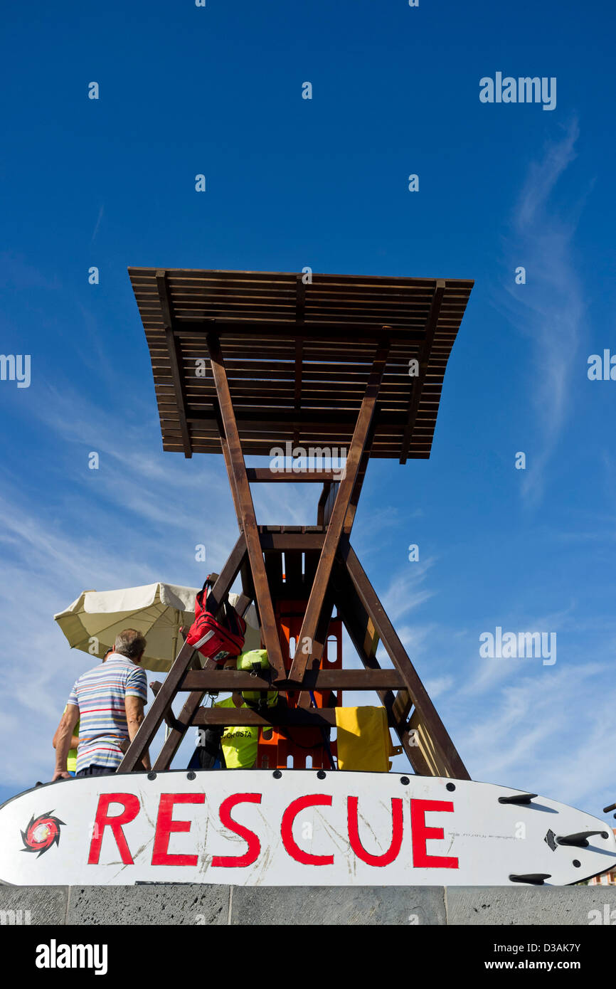 Lifeguard rescue station with wooden tower and surfboard marked rescue