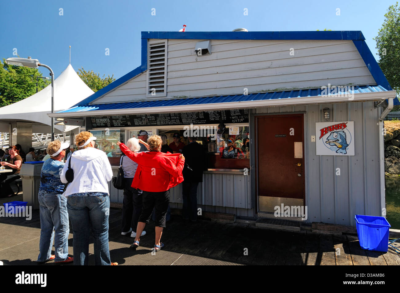 tourists queuing for fish and chips barbs seafood stall stand takeaway fast food fishermans wharf victoria vancouver island Stock Photo
