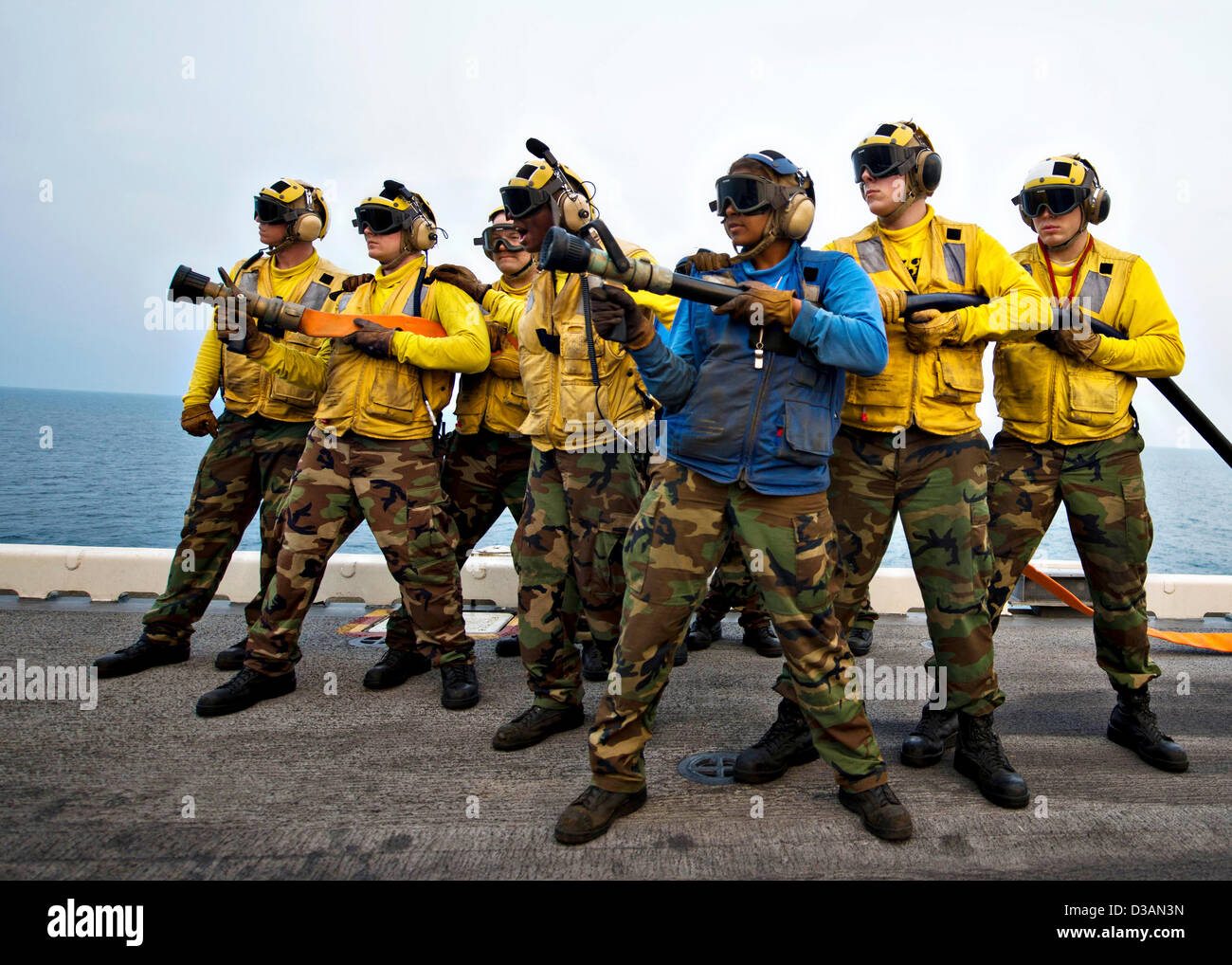 US Navy Fire hose teams stand by during a simulated aircraft crash mass casualty drill aboard the amphibious assault ship USS Bonhomme Richard February 13, 2013 in the Gulf of Thailand. The Bonhomme Richard Amphibious Ready Group is taking part in Cobra Gold, a Thai-U.S. joint exercise. Stock Photo