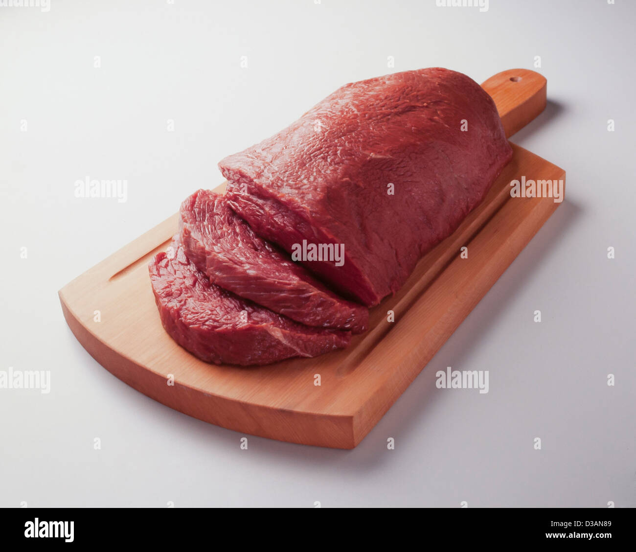 fresh and lean raw meat cut into portions on wooden board Stock Photo