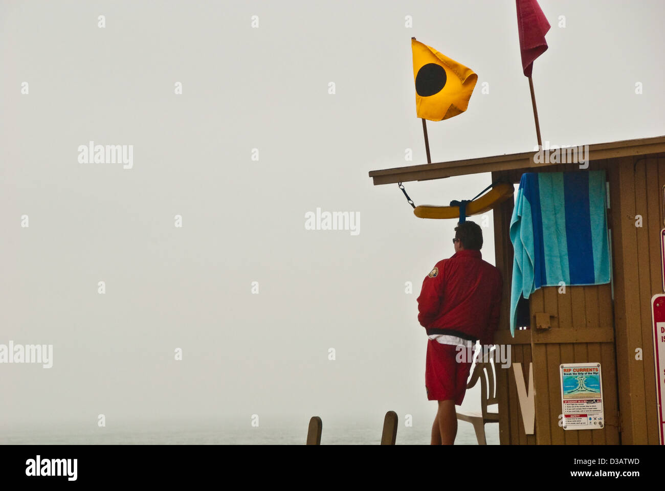 Lifeguard at The Wedge in Newport Beach on a foggy California morning. The Blackball flag indicates bodysurfing only. Stock Photo
