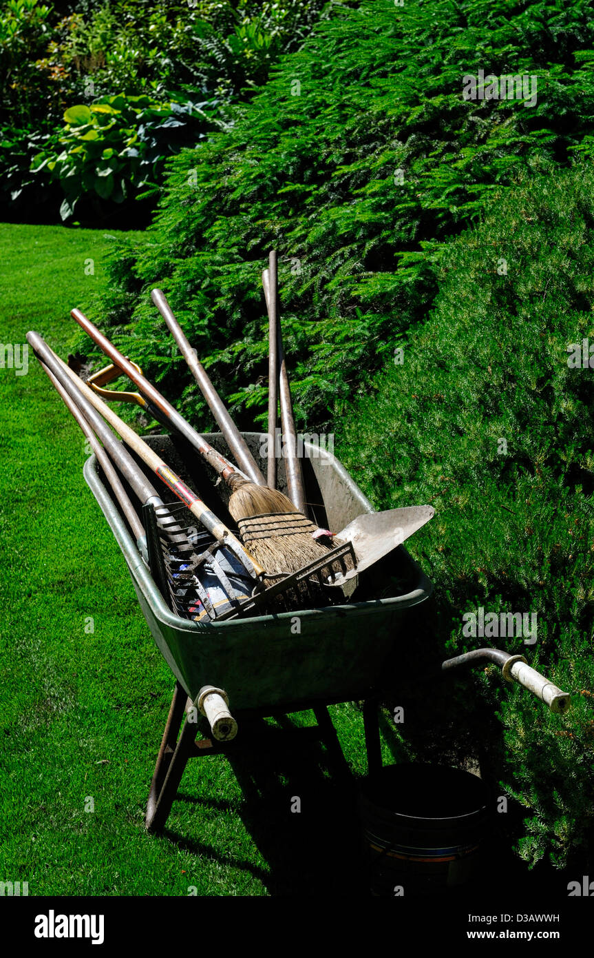 wheelbarrow fill filled full garden gardening tools implements rake shovel brush spade summer