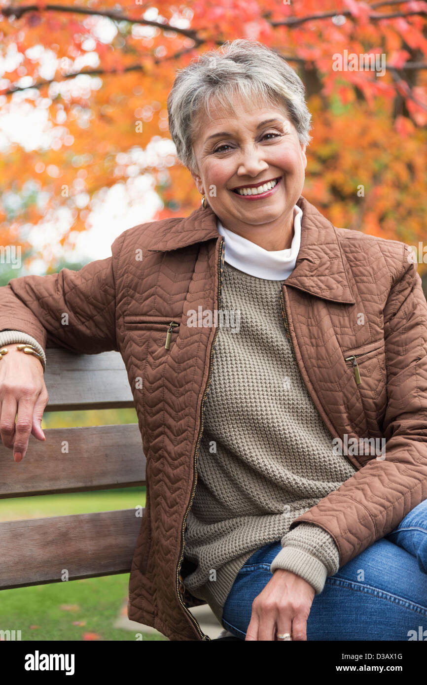 Mixed race woman on park bench Stock Photo