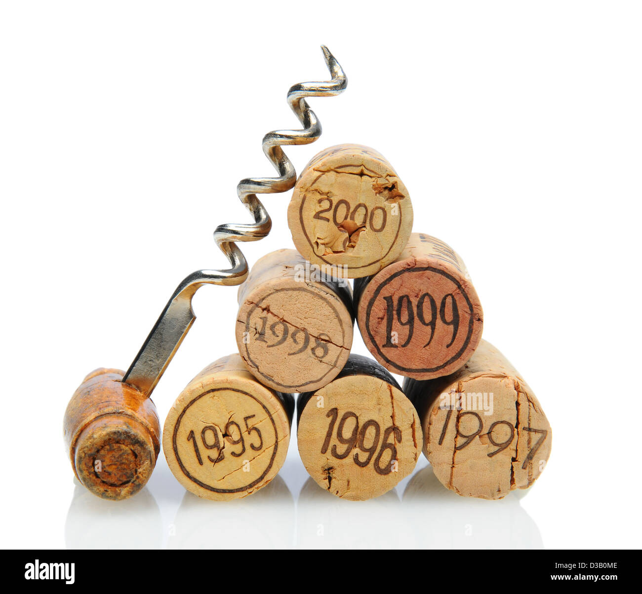 Closeup of a group of vintage dated wine corks and an antique corkscrew on white with reflection. Stock Photo