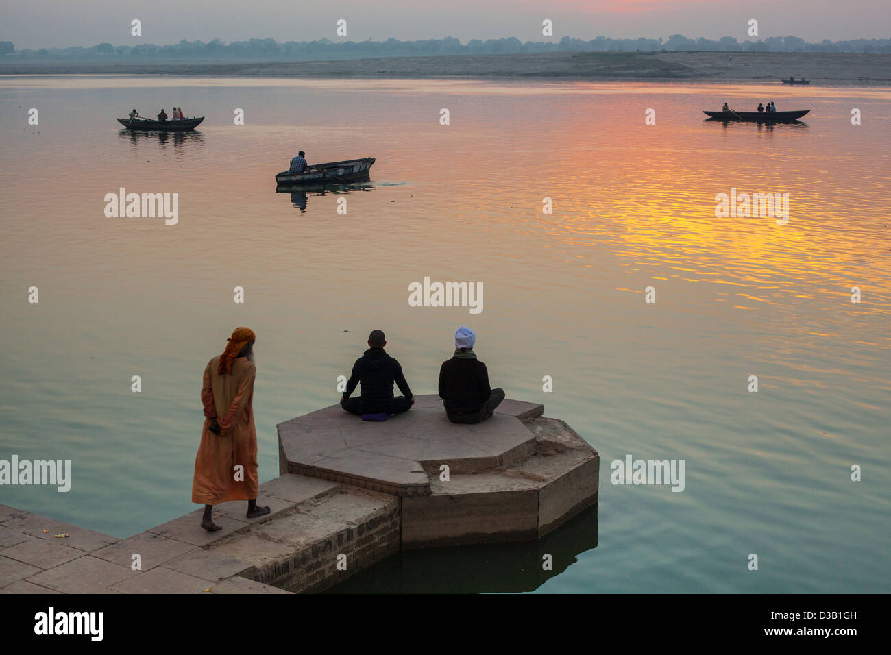 men meditating at dawn, Varanasi, India Stock Photo