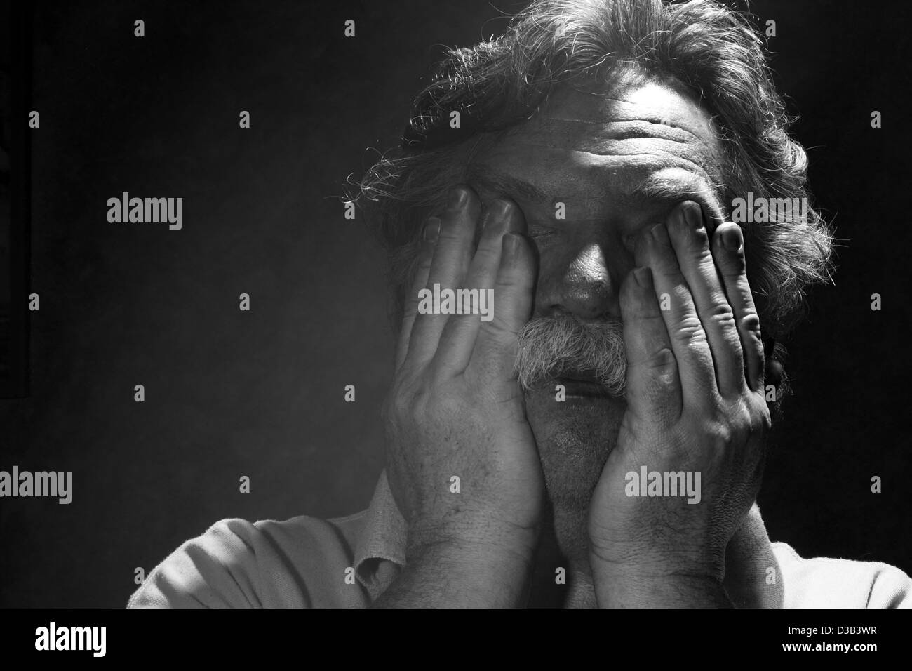 tired middle-aged man rubs his eyes, black and white Stock Photo