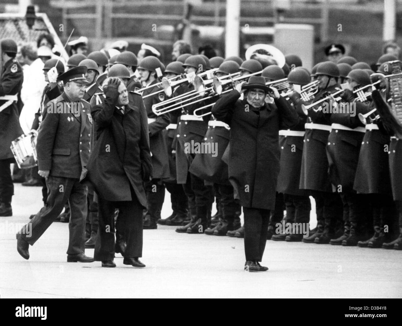 (dpa files) - Soviet leader Leonid Brezhnev (R) has to hold tight to his hat due to windy weather as he walks past the honour guard of the German army together with German Chancellor Helmut Schmidt (L) during the ceremony concluding his state visit to Germany, , Hamburg, 7 May 1978. Stock Photo