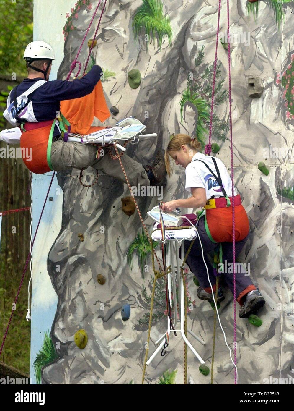 (dpa) - Ironing as fun and challenge: Two participants in the first extreme ironing world championships are pressing laundry as they are hanging in a climbing wall near Valley, Bavaria, 21 September 2002. The championships consist of five disciplines including forest, urban, freestyle and rocky with Stock Photo
