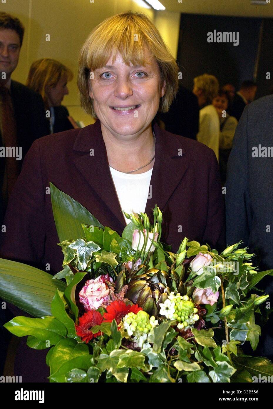(dpa) - Angela Merkel, chairwoman of the CDU and newly elected leader of the CDU fraction in the Bundestag, holds a bouquet of flowers and smiles at the photographers, Berlin, 24 September 2002. 214 MPs of the CDU/CSU fraction voted for the 48-year-old, 18 voted 'no', eleven votes were invalid. Ange Stock Photo