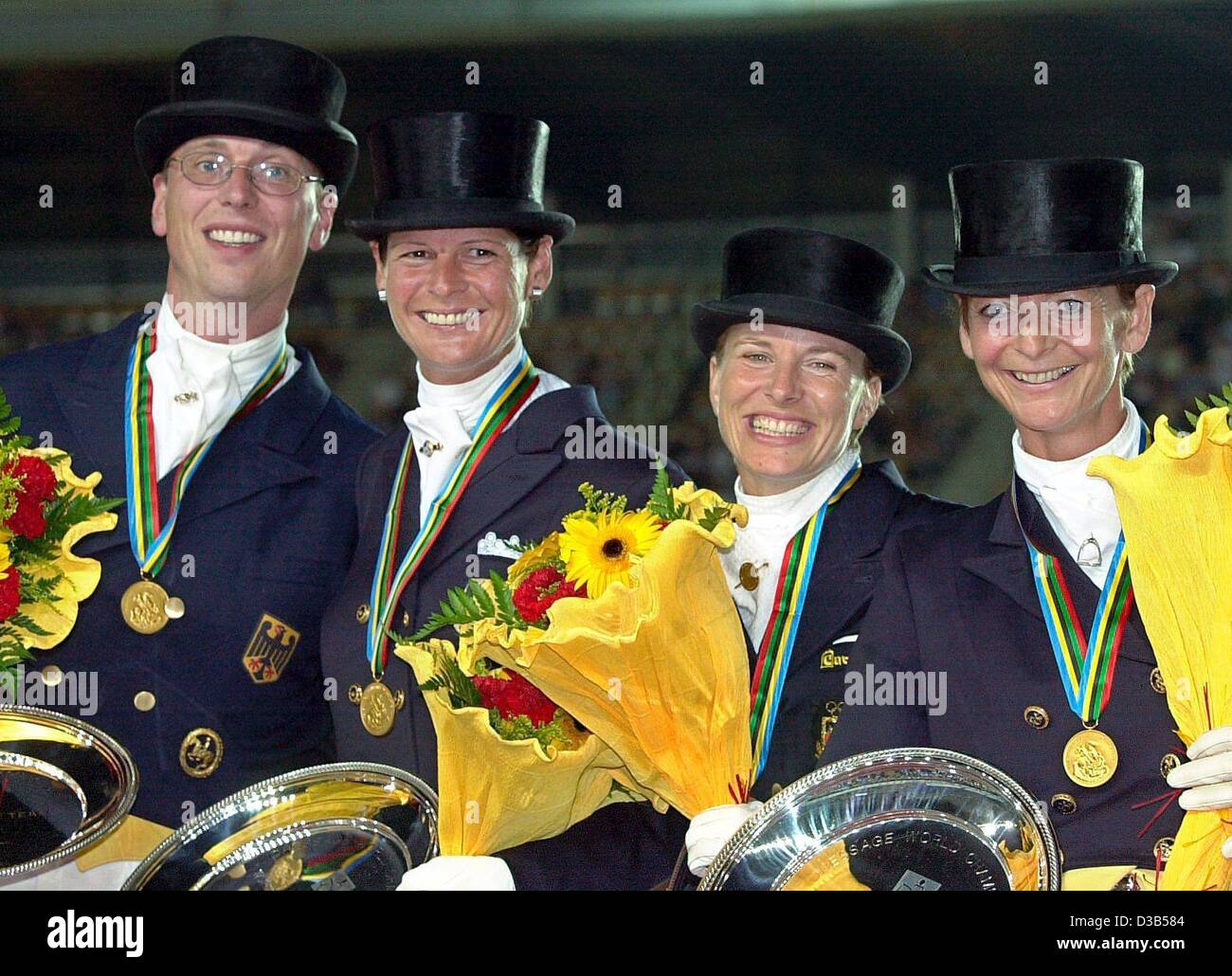 (dpa) - The riders of the German dressage equipe, L-R: Klaus Husenbeth, Ulla Salzgeber, Nadine Capellmann and Ann Kathrin Linsenhoff, pose with their gold medals after winning the dressage team event at the World Equestrian Games in Jerez, Spain, 12 September 2002. Stock Photo