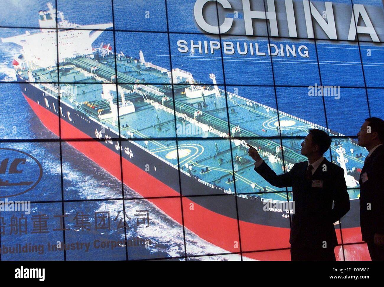 (dpa) - Two men look at a screen showing a photo of a Chinese super tanker on the opening day of the International Shipbuilding Trade Fair SMM in Hamburg, 24 September 2002. 1400 exhibitors from 52 nations present their products of Shipbuilding, Machinery and Marine Technology until 28 September. Ch Stock Photo
