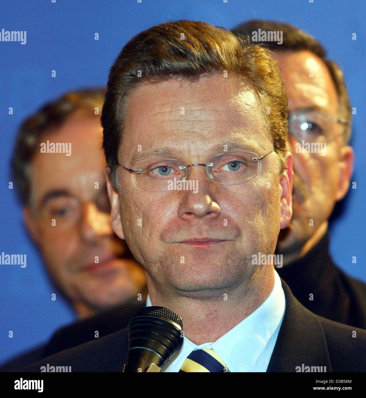 (dpa) - Guido Westerwelle (C), Chairman of the Liberal Party FDP, comments on the disappointing preliminary results after the elections in the FDP headquarters in Berlin, 22 September 2002. In the background FDP Committee member Walter Doering (R). According to estimates the FDP wins only 7.4 per ce Stock Photo