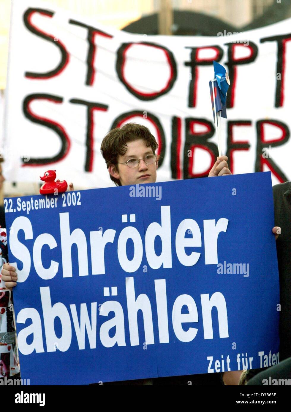 (dpa) - Opponents of chancellor Schroeder as well as opponents of chancellor candidate Stoiber protest during Stoiber's election campaign event in Hanover, Germany, 9 September 2002. The poster in the foreground reads 'Vote Schroeder out of office' next to Stoiber's election campaign slogan 'Time fo Stock Photo