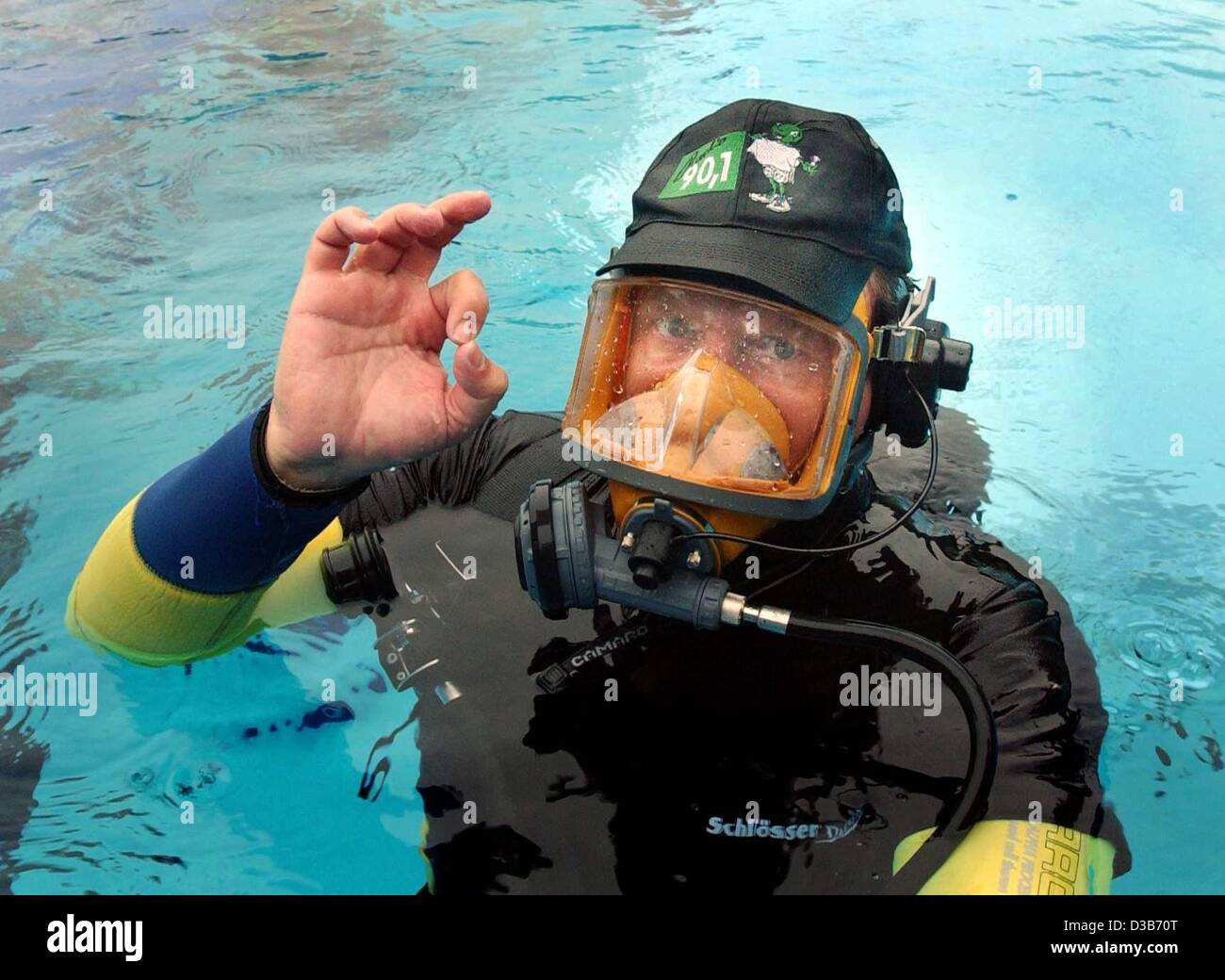 (dpa) - German radio host Frank Niessen gives the 'ok' sign before he dives to the ground of a swimming pool in Moenchengladbach, Germany, in order to present his complete morning show 'city talk' under water, 3 August 2002. Despite some difficulties in speaking and in changing his air tank, the 39- Stock Photo