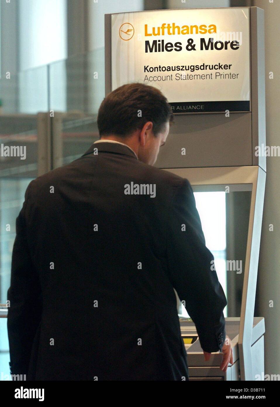 (dpa) - A Lufthansa client waits for the printout of his account statement at the 'Miles & More' account printer at the airport in Duesseldorf, 2 August 2002. Recently several German politicians had to step back after it evolved that they used free flight miles for private flights. Lufthansa now sta Stock Photo