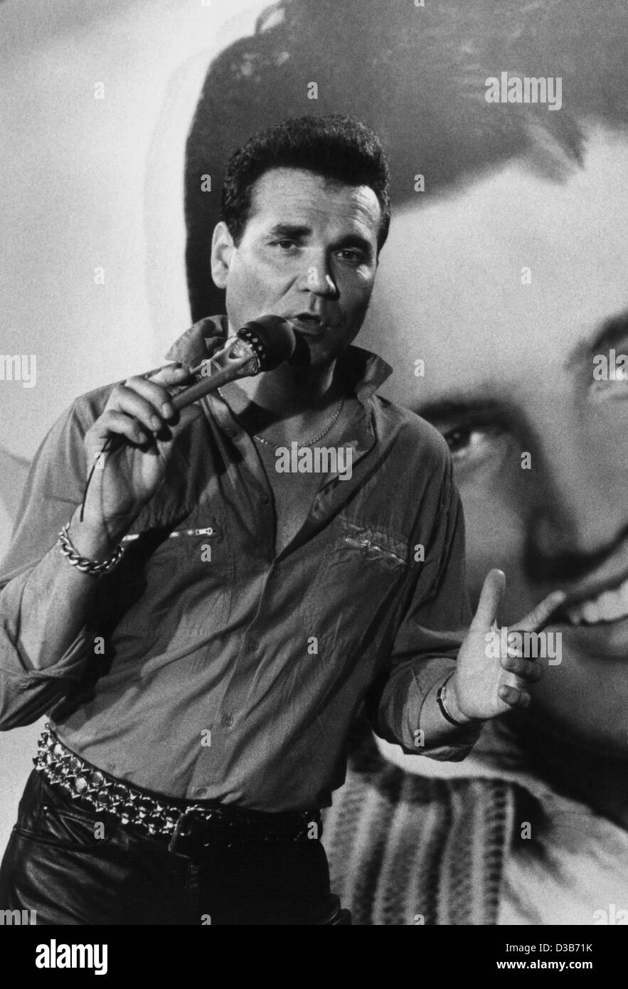 (dpa files) - German Rock'N'Roll legend Ted Herold performs in front of an Elvis Presley poster in Hamburg, 14 August 1987. Herold will celebrate his 60th birthday on 9 September 2002. He started his career in his high school time after he had got a guitar for Christmas in 1956. 'The German Elvis Pr Stock Photo