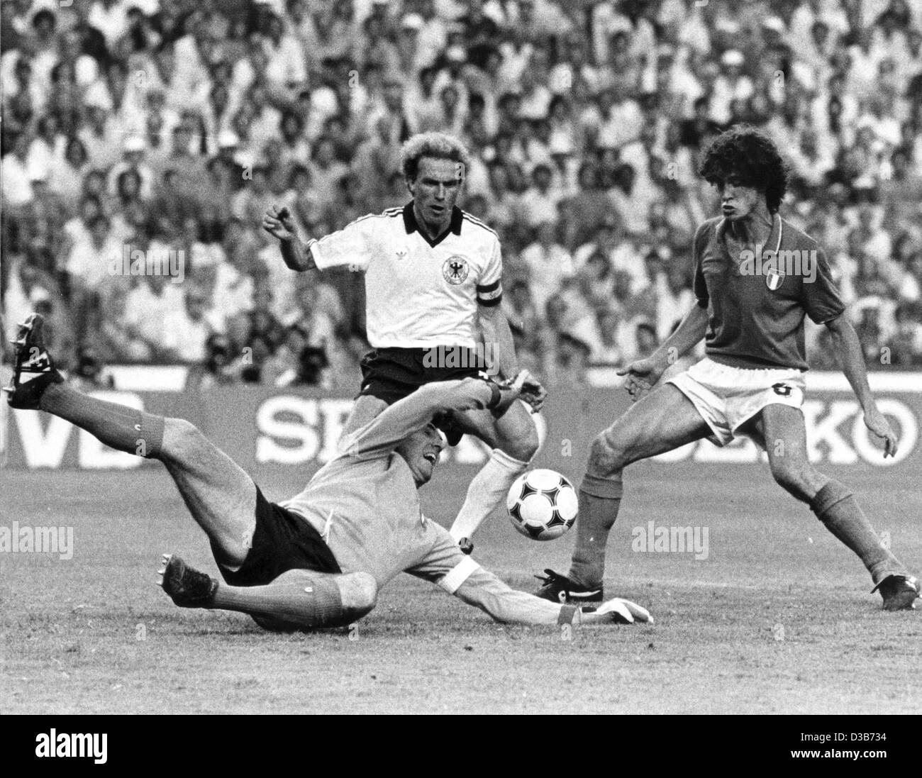 (dpa files) - Italian goalkeeper Dino Zoff jumps for the ball in front of his team mate, defender Fulvio Collovati (R), and Germany's striker Karl-Heinz Rummenigge (C) during the final World Cup match in the Santiago-Bernabeu stadium in Madrid, 11 July 1982. Italy beat Germany 3:1. Stock Photo