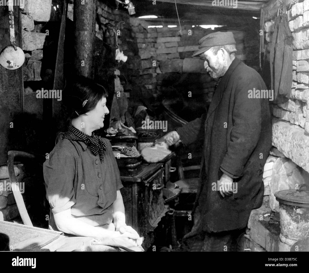 (dpa files) - Two inhabitants of a scanty brick hut prepare a meal, in post-war Frankfurt, western Germany, 1946. Stock Photo
