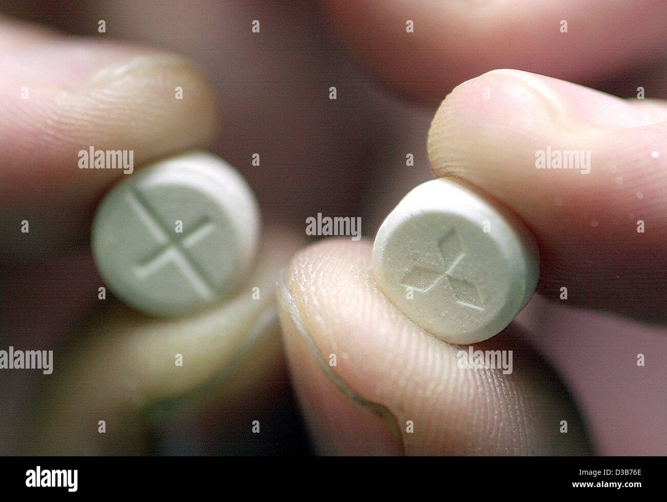 (dpa) - A police officer holds up two ecstasy pills in the police department in Frankfurt, 23 December 2002. Stock Photo