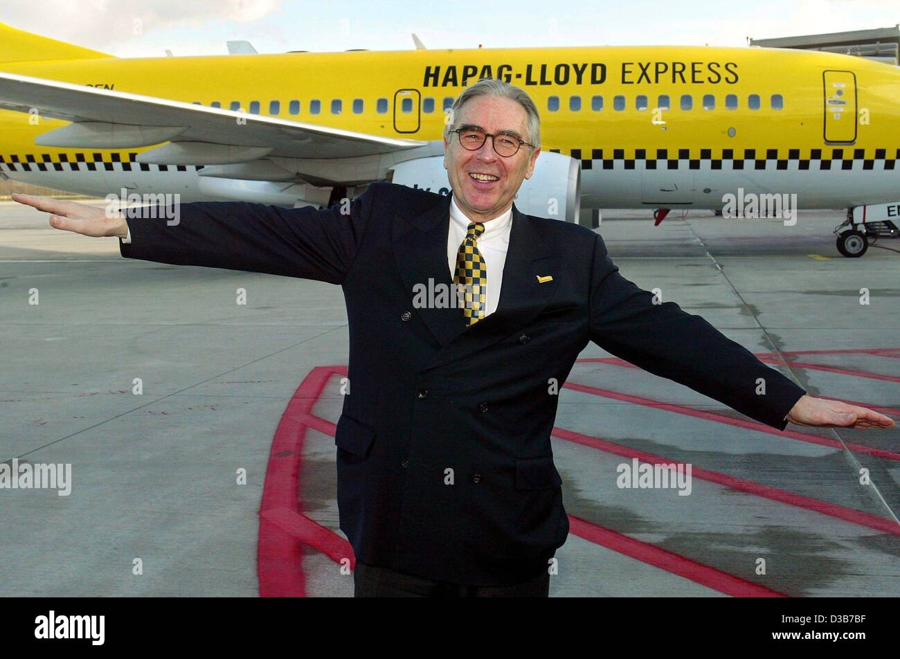 (dpa) - Wolfgang Kurth, general manager of the airline Hapag-Lloyd Express, stretches his arms simulating an aircraft at the Cologne Bonn Airport, 3 December 2002. The Boeing 737-700 in the background with its striking yellow coating reminds of New York cabs. Hapag-Lloyd Express belongs to the TUI g Stock Photo
