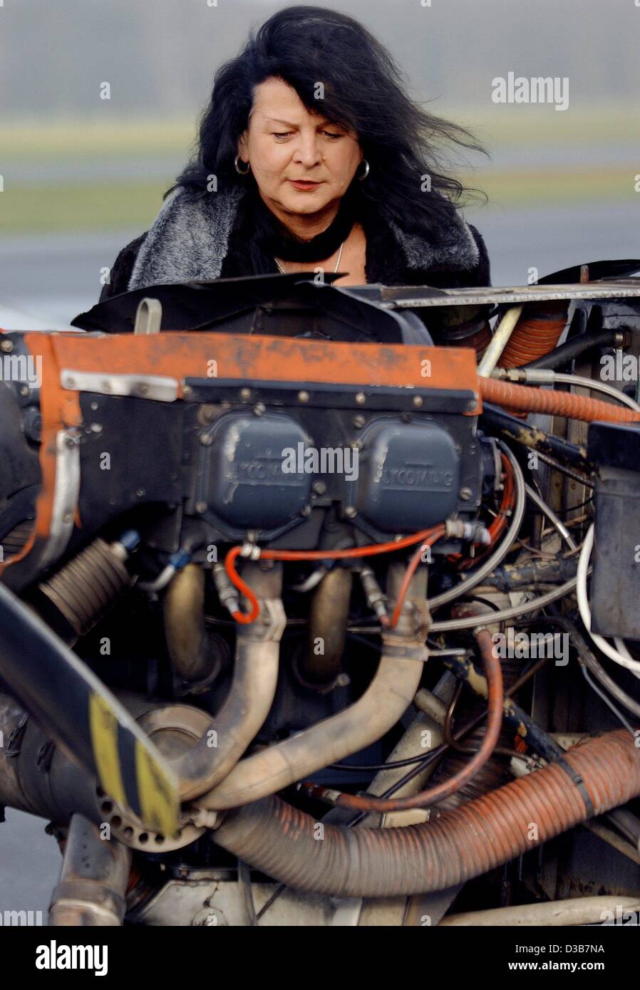 (dpa) - Kimberly Marx is checking her single engine aircraft (Morane, 180 horsepower) before taking off from regional airport Dinslaken, Germany, 26 November 2002. Kimberly, who was a man called 'Manfred' until 1996, has been in the business for 25 years. She is showing the banner of the circus 'Fli Stock Photo